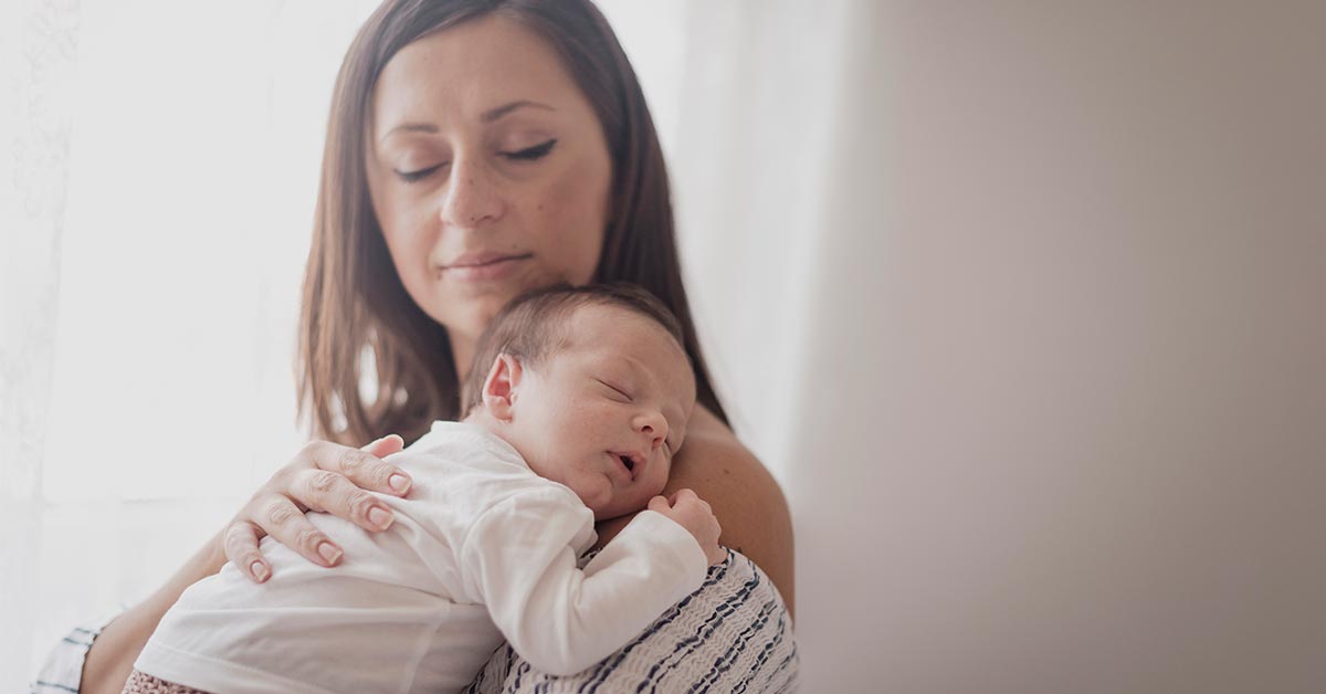 Bebê dormindo no colo da mãe