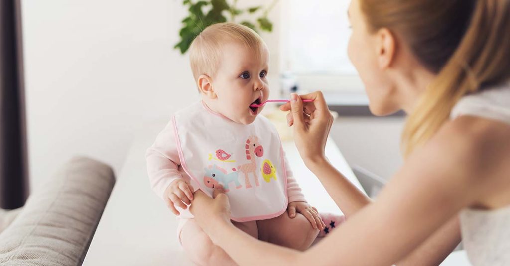 Mãe dando papinha pro bebê